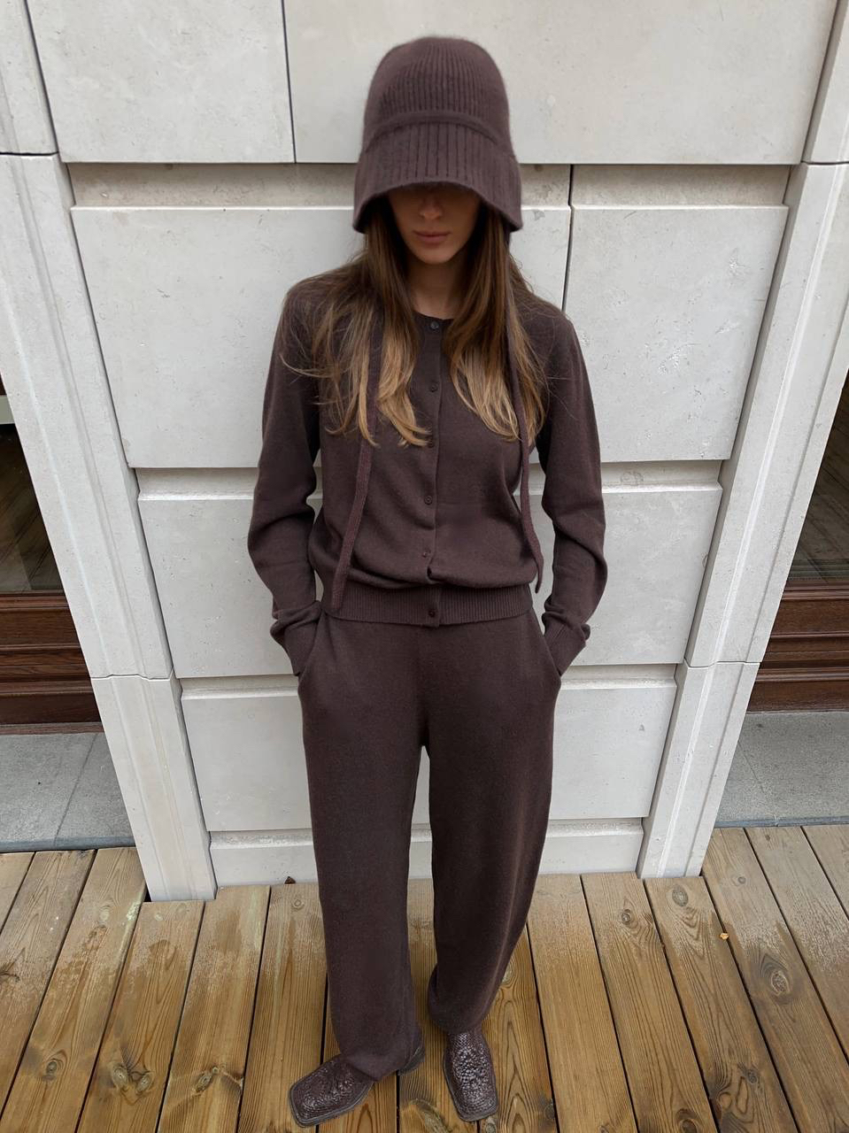 Расслабленный образ, в основе которого сет из вязаного трикотажа. Монохромный коричневый с кардиганом, свободными брюками и панамой на завязках 