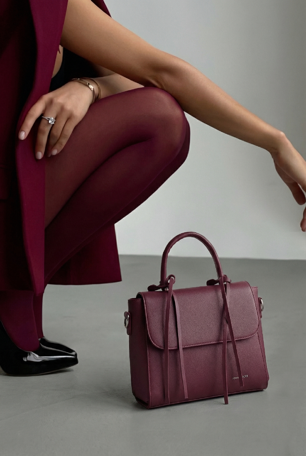 Не бойтесь экспериментировать с формой. Сумка может быть необычной или винтажной. Главное, чтобы она вызывала у вас улыбку, когда вы берете её в руки. Именно такая есть в новой коллекции JOHN LOCKE — бордовая с 2 ручками в комплекте и шлейками для декора 