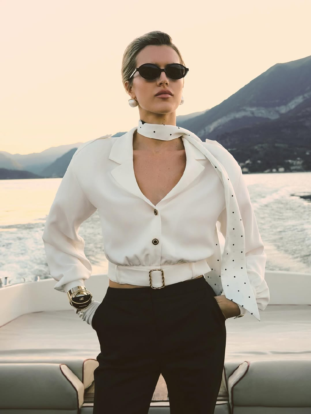 Блуза La Cintura Bianca из вискозного крепа с
объемной линией плеч и золотистыми пуговицами возвращает к эстетике 80-х и придает образу динамику.

Брюки-сигареты на высокой посадке поддерживают четкий силуэт и создают ощущение легкости в движении.
Вместе они формируют современный образ, в котором классика звучит свежо и актуально